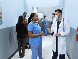 Doctors and nurses in a hospital hallway discussing medical matters.