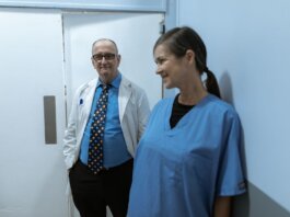 Doctors and nurses interacting in a hospital hallway, showcasing teamwork and professionalism.