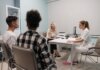 Doctors talking with patients during a medical appointment in a clinic office setting.