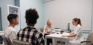 Doctors talking with patients during a medical appointment in a clinic office setting.
