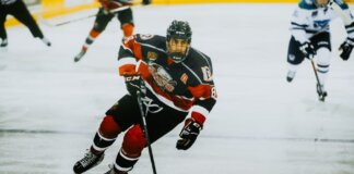 Dynamic action shot of a hockey player skating on an ice rink during a game.