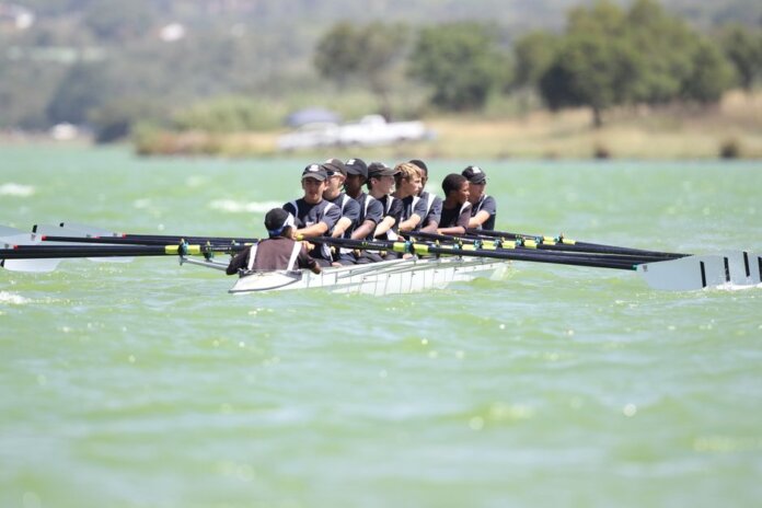Energetic rowing team practicing on a serene lake during daylight showcasing teamwork and coordination. Energetic rowing team practicing on a serene lake during daylight showcasing teamwork and coordination.