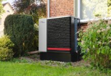 Energy-efficient heat pump in a green residential garden setting.