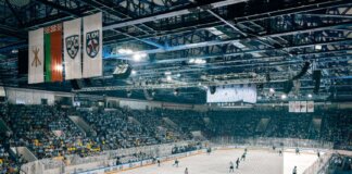 Exciting ice hockey game with players and crowd in a vibrant indoor arena atmosphere.