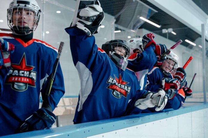 Group of ice hockey players in blue jerseys celebrating a win indoors. Group of ice hockey players in blue jerseys celebrating a win indoors.