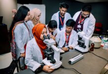 Group of students conducting a lab experiment in a university setting.