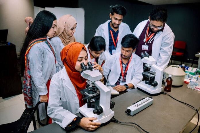 Group of students conducting a lab experiment in a university setting. Group of students conducting a lab experiment in a university setting.