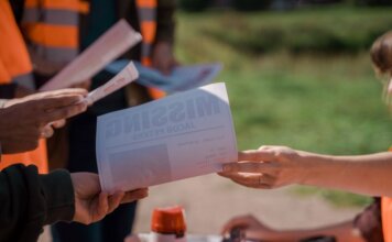 Полиция Калгари ищет 30-летнего Владислава, пропавшего в марте 2026 года Group of volunteers handing out missing person flyers during a search operation outdoors.