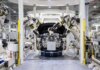 Оттава инвестирует в Prevost в Квебеке: завод Volvo переходит на электрические автобусы High-tech robots assembling a car in a modern factory setting, showcasing automation.