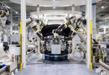 High-tech robots assembling a car in a modern factory setting, showcasing automation.
