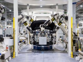 High-tech robots assembling a car in a modern factory setting, showcasing automation.