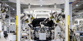 High-tech robots assembling a car in a modern factory setting, showcasing automation.