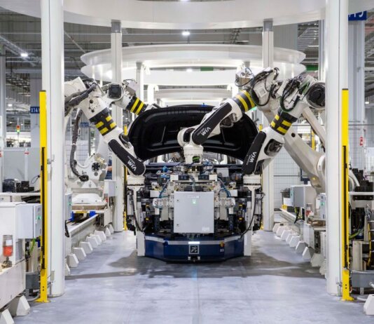 High-tech robots assembling a car in a modern factory setting, showcasing automation.