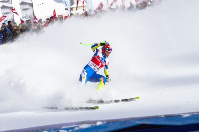 Intense ski race action captured with athlete carving through snowy slope in winter. Intense ski race action captured with athlete carving through snowy slope in winter.