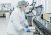 Laboratory scientist in protective gear working with medical samples.