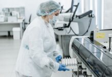Джордж Мутвири назначен в Руководящий совет Канадских институтов исследований здоровья Laboratory scientist in protective gear working with medical samples.