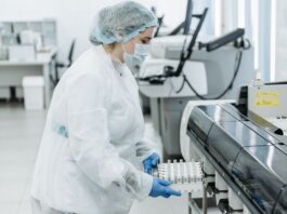 Laboratory scientist in protective gear working with medical samples.