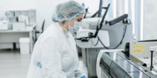 Laboratory scientist in protective gear working with medical samples.
