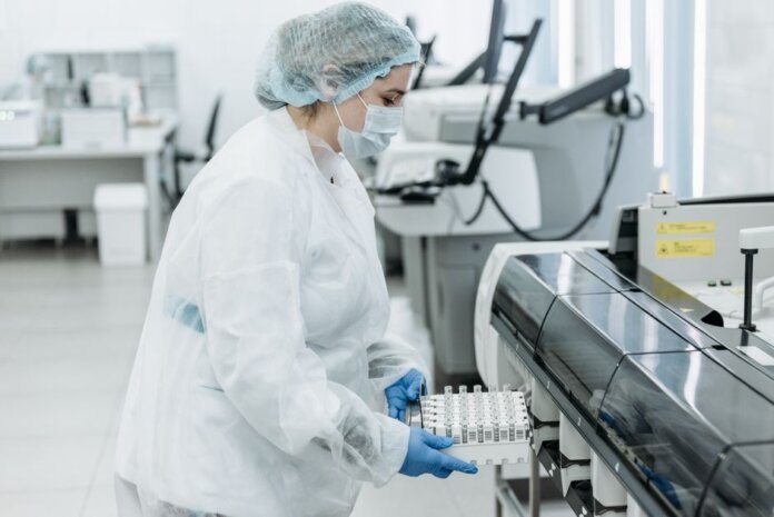 Laboratory scientist in protective gear working with medical samples. Laboratory scientist in protective gear working with medical samples.
