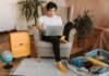 Booking.com: как сервис помогает путешественникам планировать и управлять поездками Man sitting on armchair planning travel, using laptop, with suitcases and globe nearby.