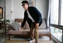 Man with sunglasses and cane navigating modern living room, embodying independence.