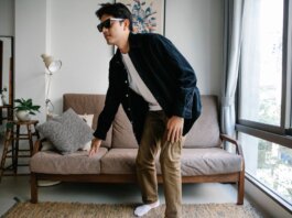 Man with sunglasses and cane navigating modern living room, embodying independence.
