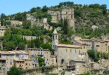 Picturesque historic stone village nestled on a hillside with lush greenery.