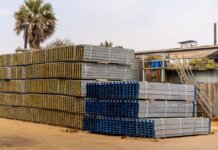 Консерваторы обвинили правительство Карни в отказе от принципа «покупай канадское» Piles of stacked metal beams in an industrial outdoor yard under a clear sky.