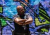 Police officer standing confidently against colorful urban graffiti wall.