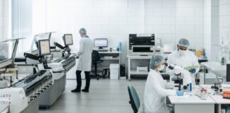 Researchers in lab coats performing experiments with advanced equipment in a laboratory.