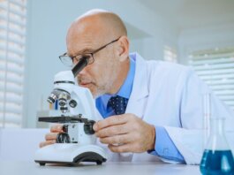 Scientist examining samples through a microscope in a modern laboratory setting.