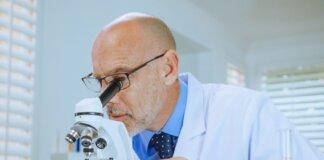 Scientist examining samples through a microscope in a modern laboratory setting.