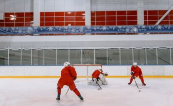 «Канадиенс» после поражения от «Каролины» отрабатывали борьбу за шайбу Three hockey players in red uniforms practicing on an indoor ice rink.