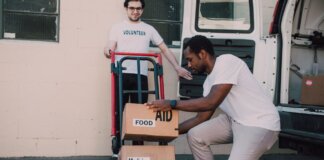 Volunteers organizing and loading boxes of aid, food, and medicine for donation.