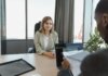 Young woman sitting confidently in a modern office for a job interview.