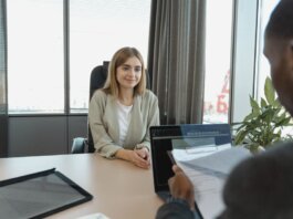 Young woman sitting confidently in a modern office for a job interview.