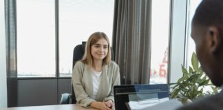 Young woman sitting confidently in a modern office for a job interview.